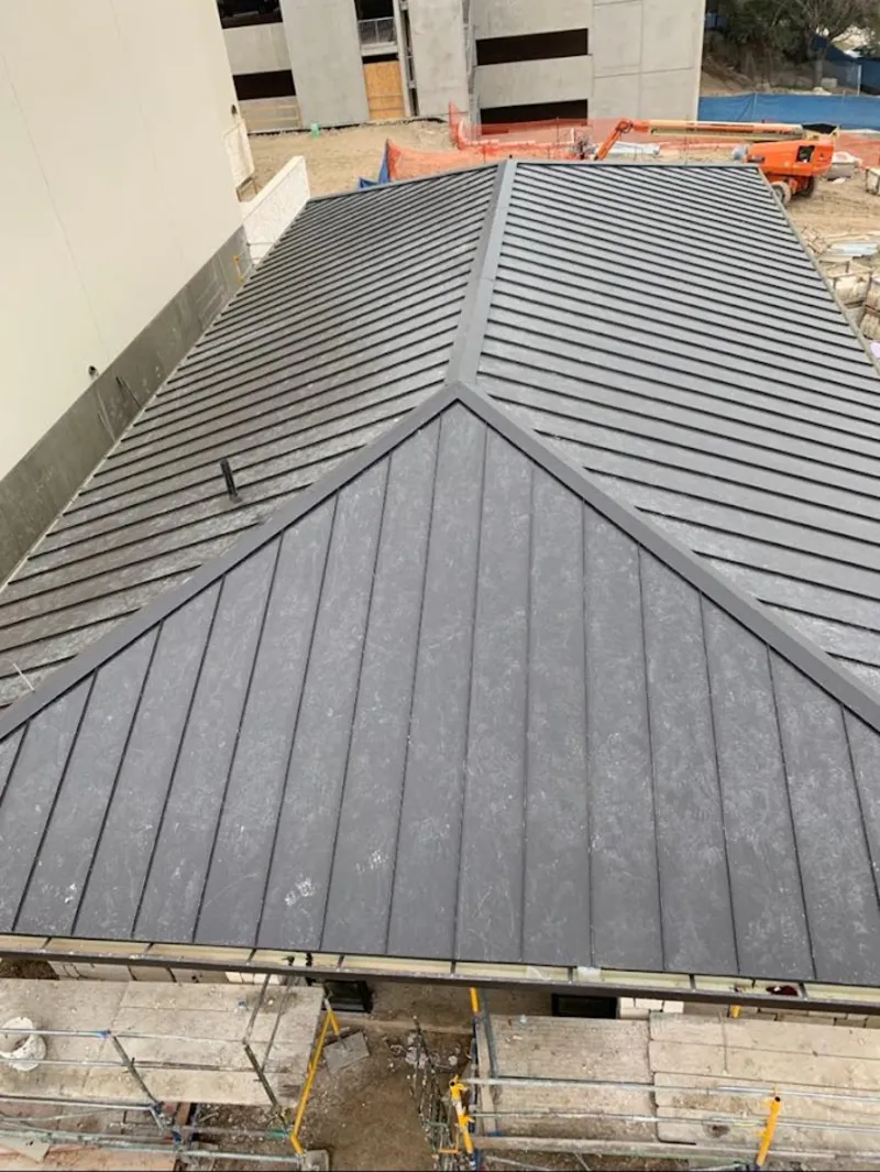 Commercial metal roof construction with crane equipment in Bluffdale